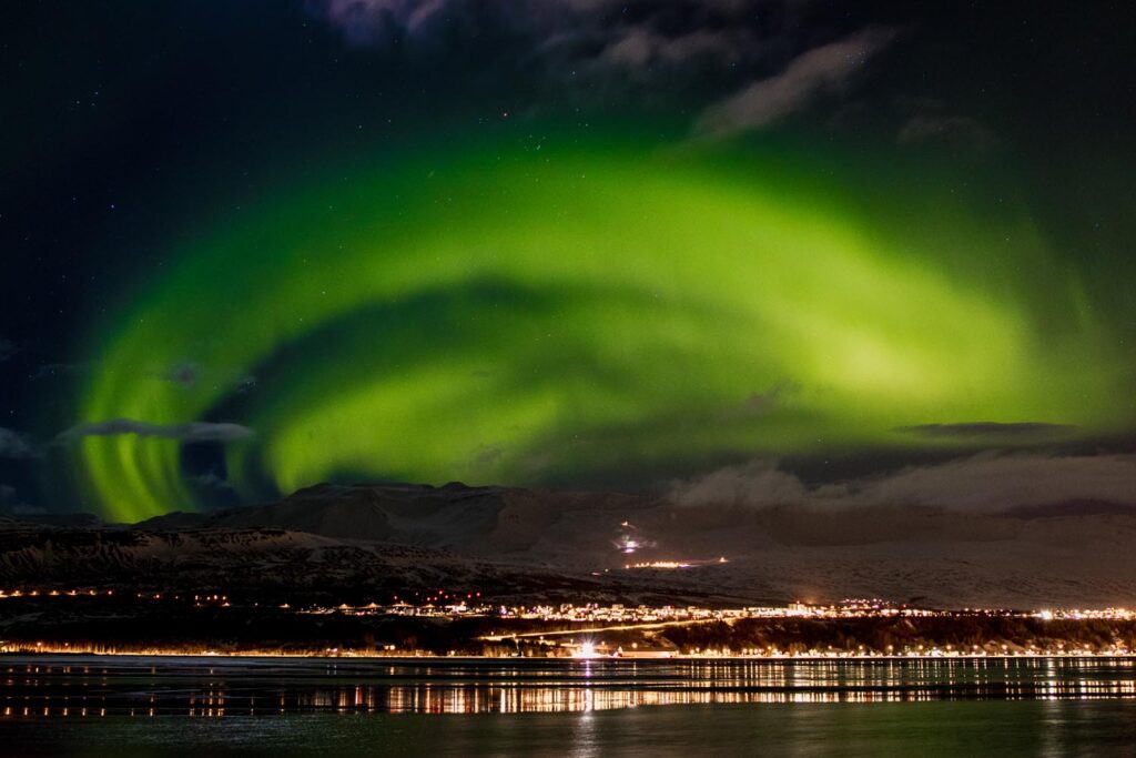 Polarlichter strahlen am Himmel über der Stadt Akureyri in Nordisland.