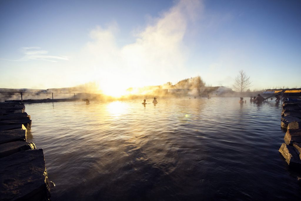 Das Thermalbad Secret Lagoon bietet besonders bei Sonnenuntergang eine faszinierende Kulisse.